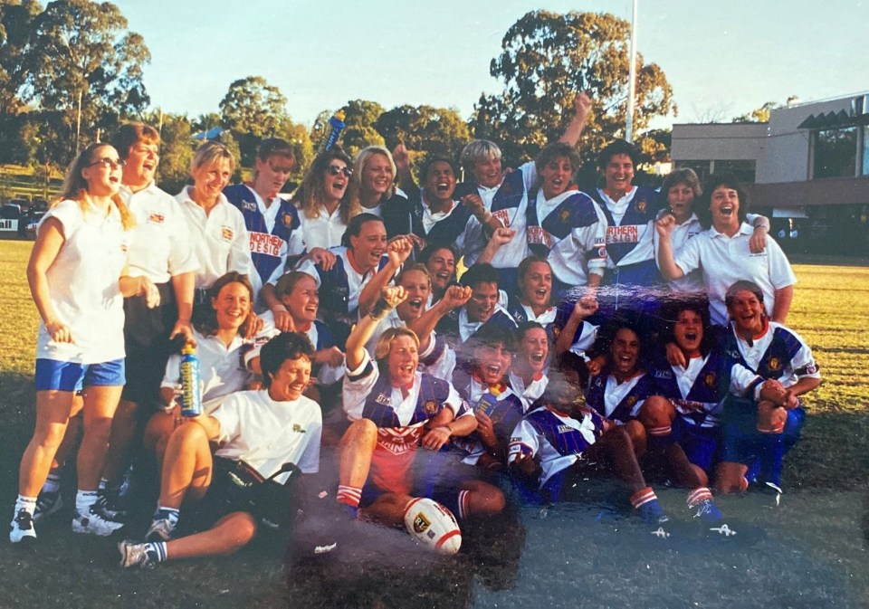 a group of female athletes are posing for a photo and one of their shirts says ' fly emirates ' on it