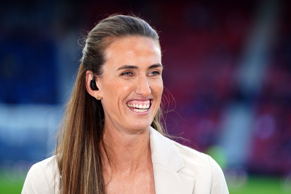 a woman wearing ear buds and a white jacket smiles