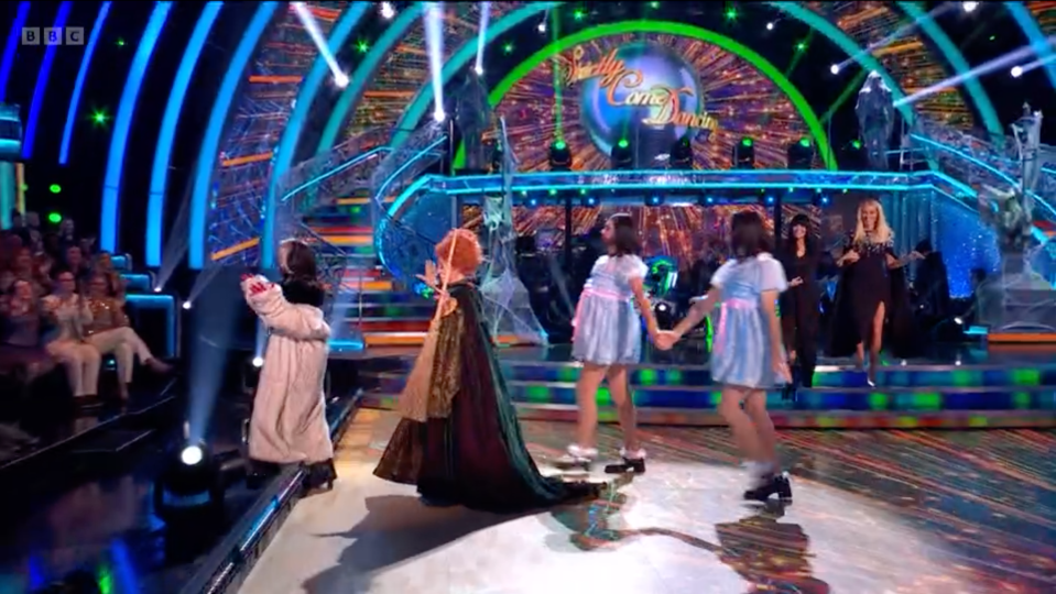 a group of people are dancing on a stage with a bbc logo in the background