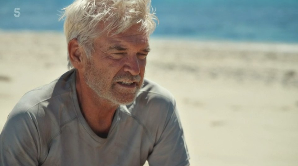 a man sitting on a beach with the number 5 on the bottom right