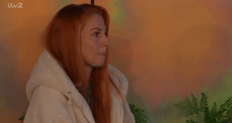 a woman with red hair is wearing a white robe