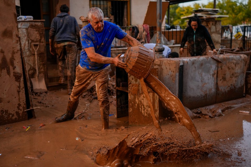 A man cleans his house affected by floods in Utiel