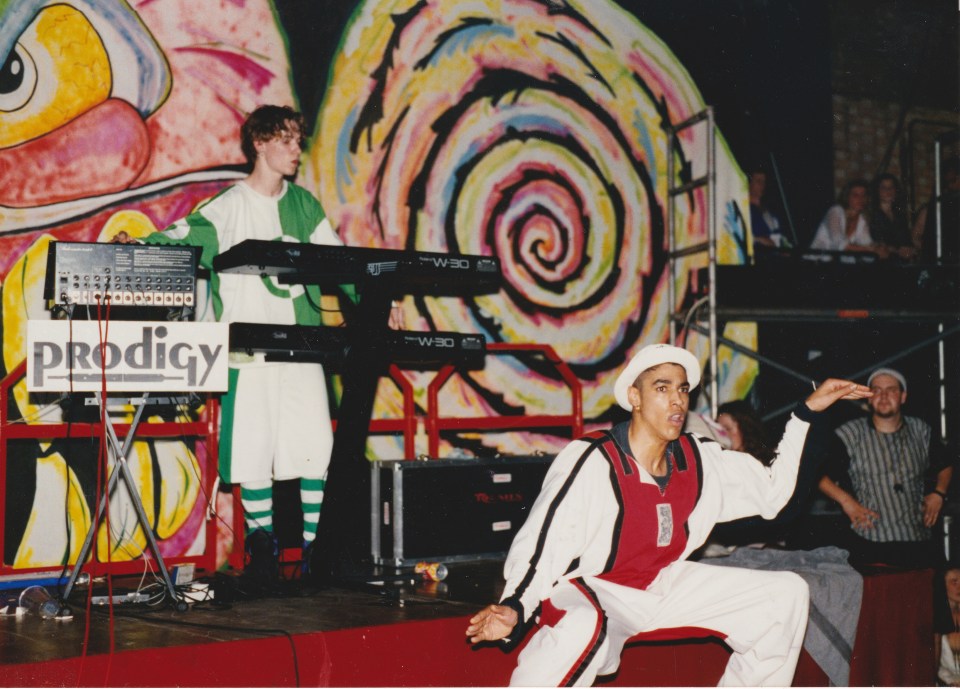 prodigy performing on stage in front of a colorful wall