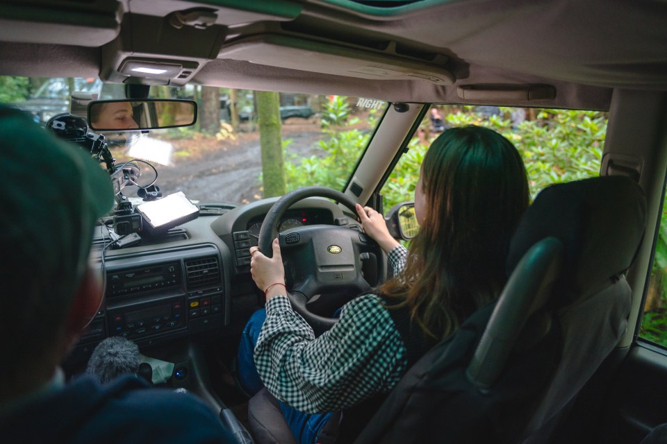 a woman driving a land rover with a sticker that says night