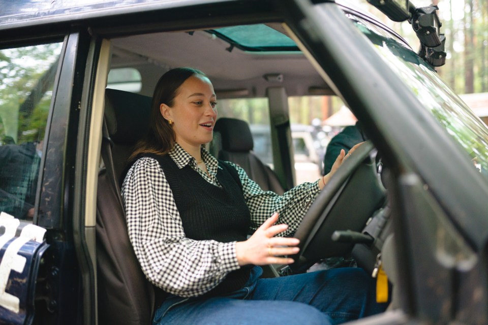 a woman is sitting in the driver 's seat of a car