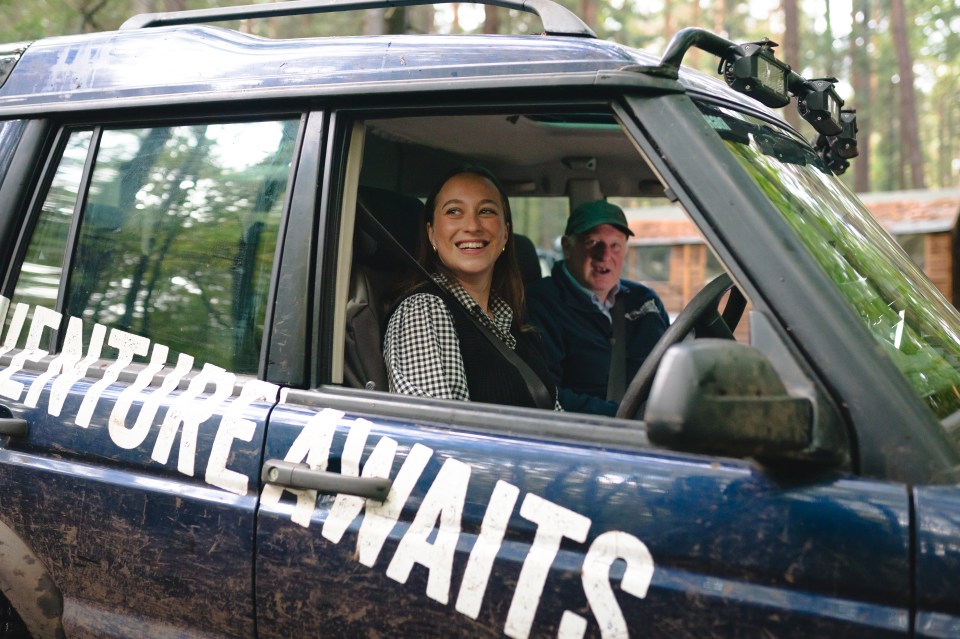 a woman sits in the driver 's seat of an adventure awaits vehicle