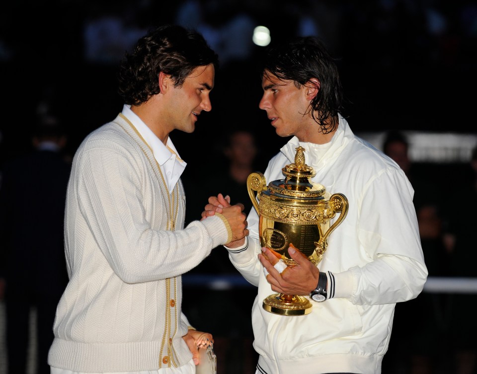 two men shaking hands while one holds a trophy