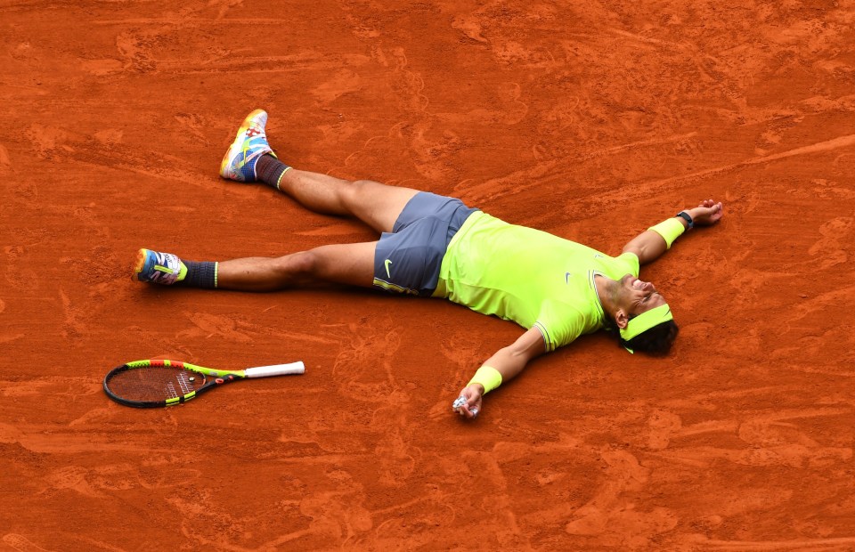 a tennis player is laying on the ground with his arms outstretched