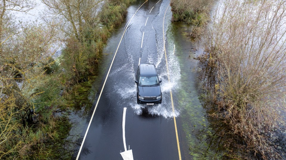 Vehicles going through the flooded A1101 on the Norfolk-Cambridge border on Sunday