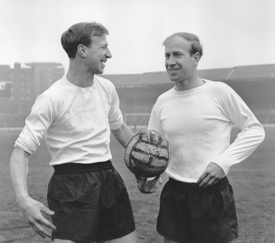 a black and white photo of two men holding a soccer ball