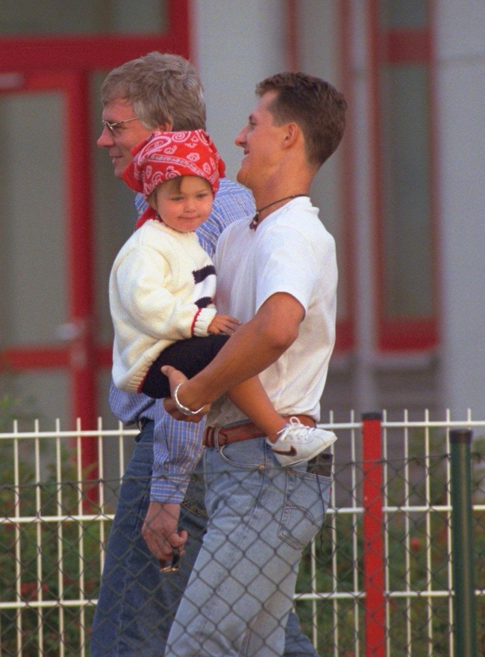 a man holding a baby with a bandana that says coca cola on it