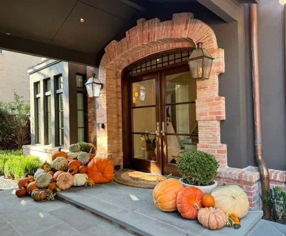 a bunch of pumpkins are on the porch of a house