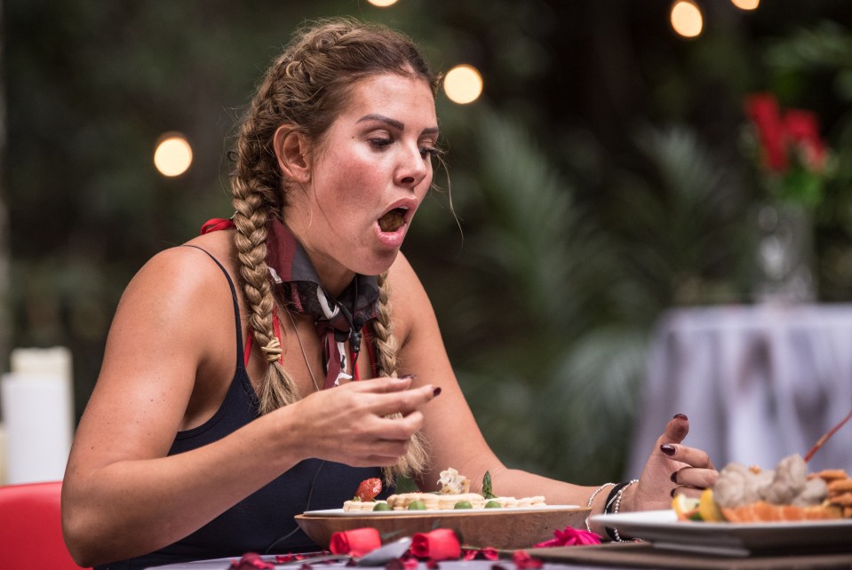 a woman sitting at a table eating a plate of food