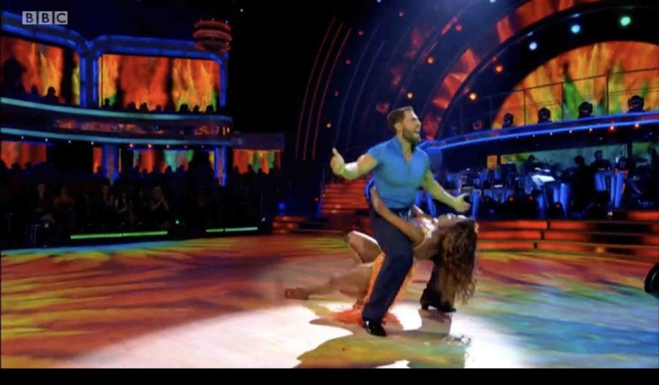 a man and a woman are dancing on a stage with bbc written on the bottom