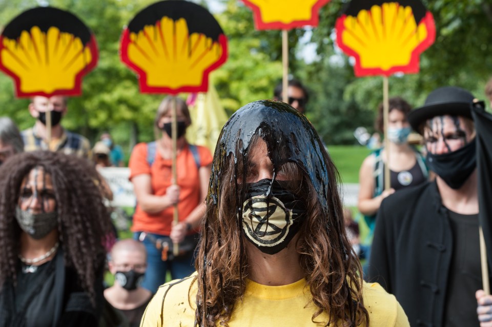 a group of protesters are holding shell signs