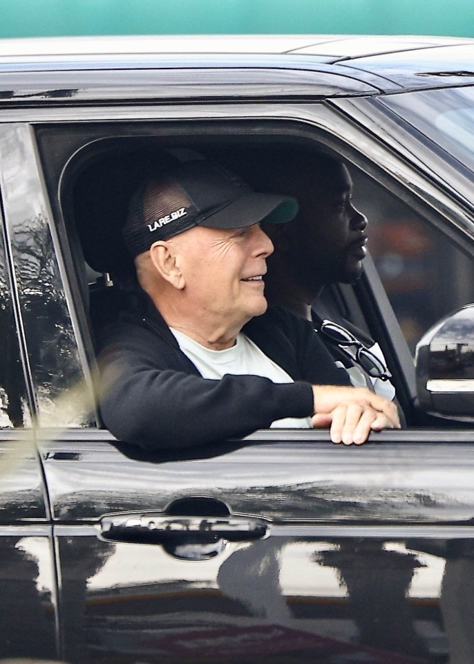 a man wearing a lapelbiz hat sits in a car