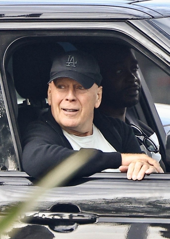 a man wearing a la hat is sitting in a car