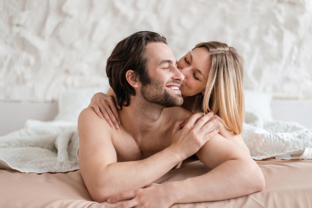 Young couple cuddling in bed.