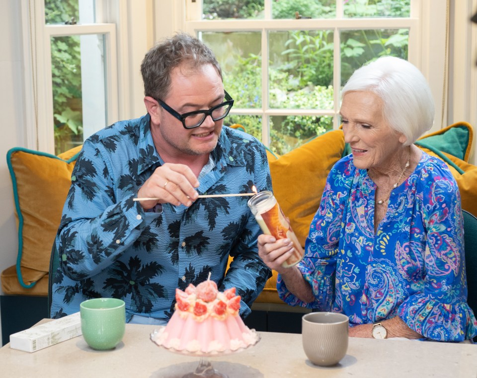 a man and a woman are sitting at a table with a cake on it