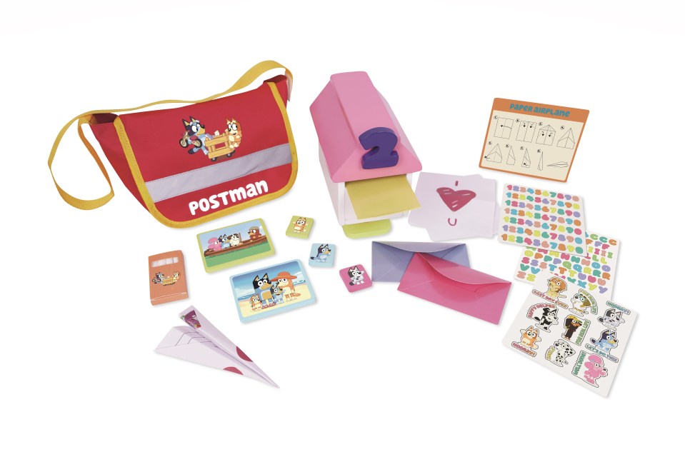 a red postman bag is surrounded by various items