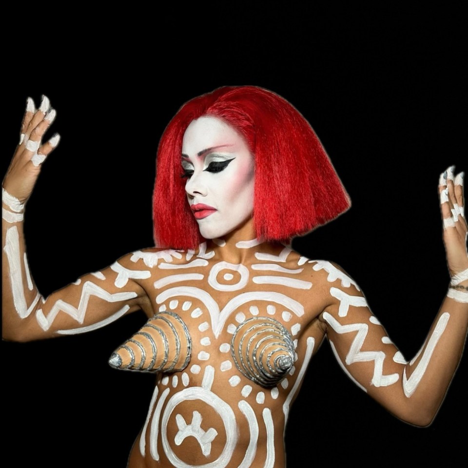 a woman with red hair and white paint on her body