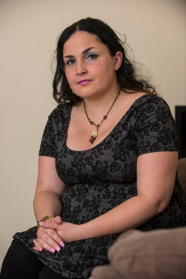 a woman sitting on a couch with her hands folded