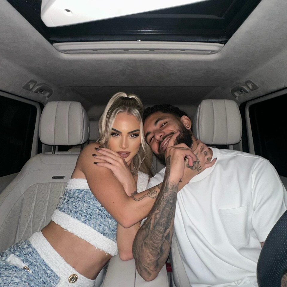 a man and a woman are posing for a picture in the back seat of a car