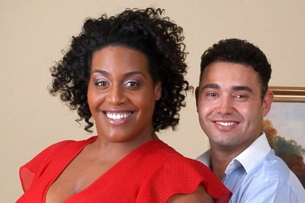 a man and a woman are posing for a picture and the woman is wearing a red top