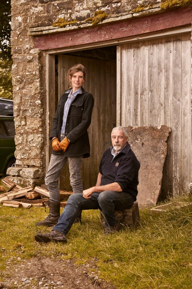 a man and a woman standing in front of a wooden building