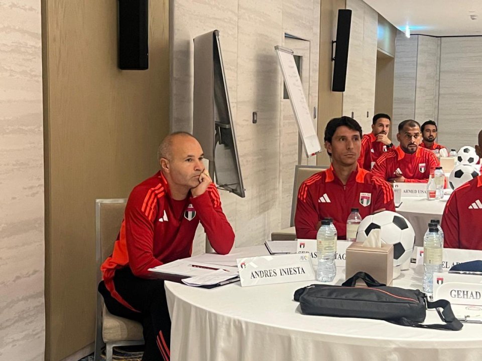 a man sits at a table with a name tag that says andres ibieta