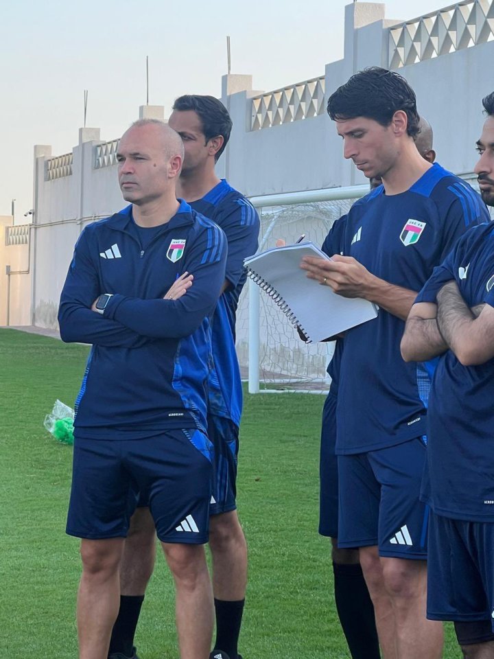 a group of soccer players are standing on a field and one of them is wearing an adidas shirt