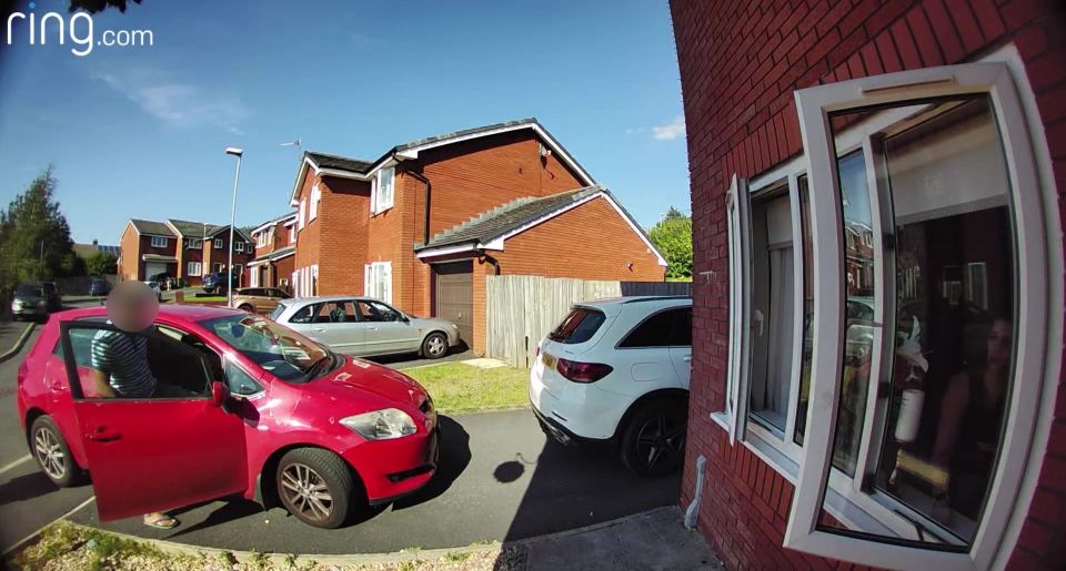 a red car is parked in front of a house with ring.com written on the bottom