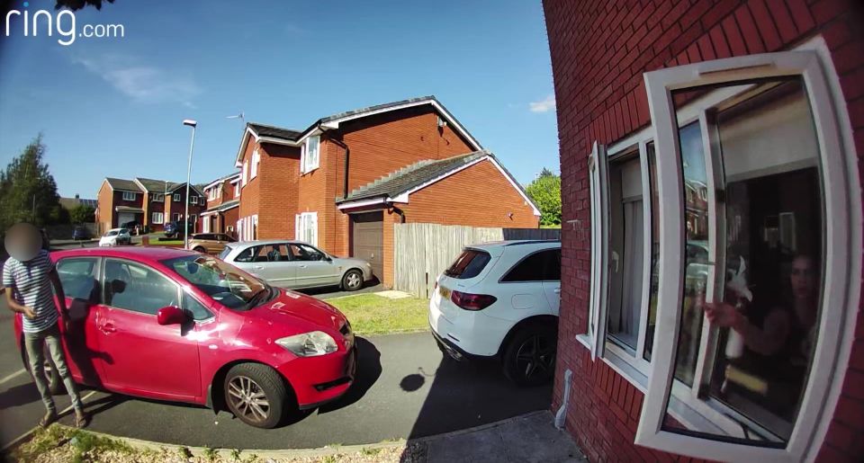 a red car is parked in front of a red brick house