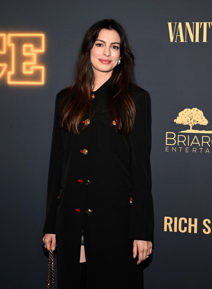 a woman stands in front of a wall that says vanity