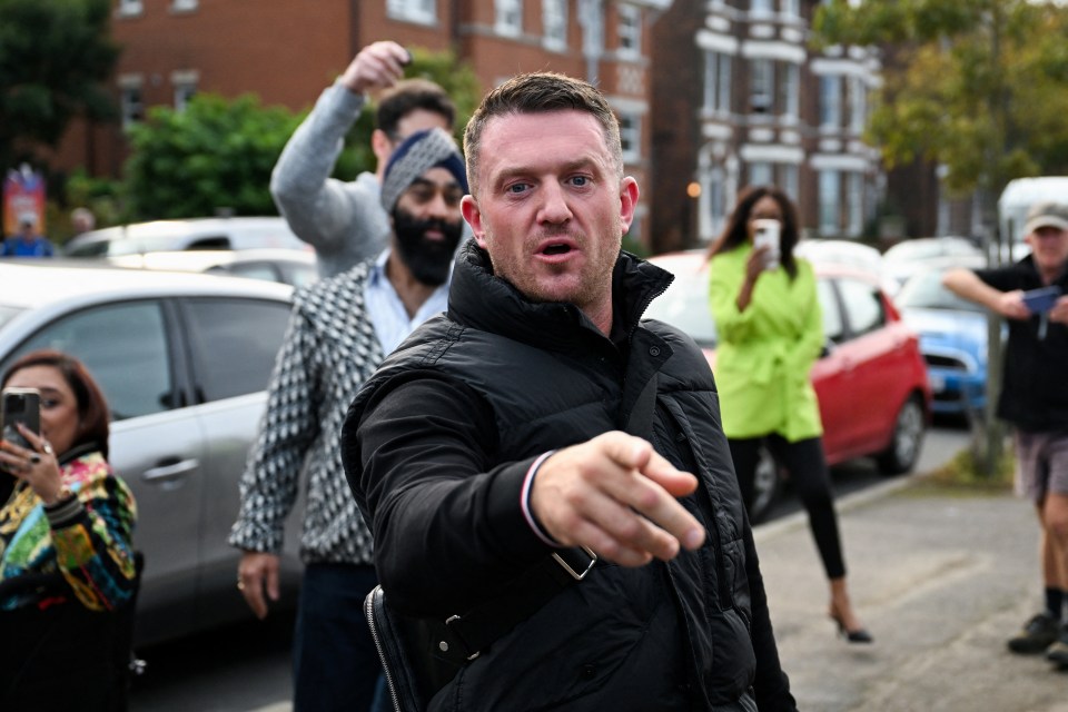 a man in a black vest is pointing at something