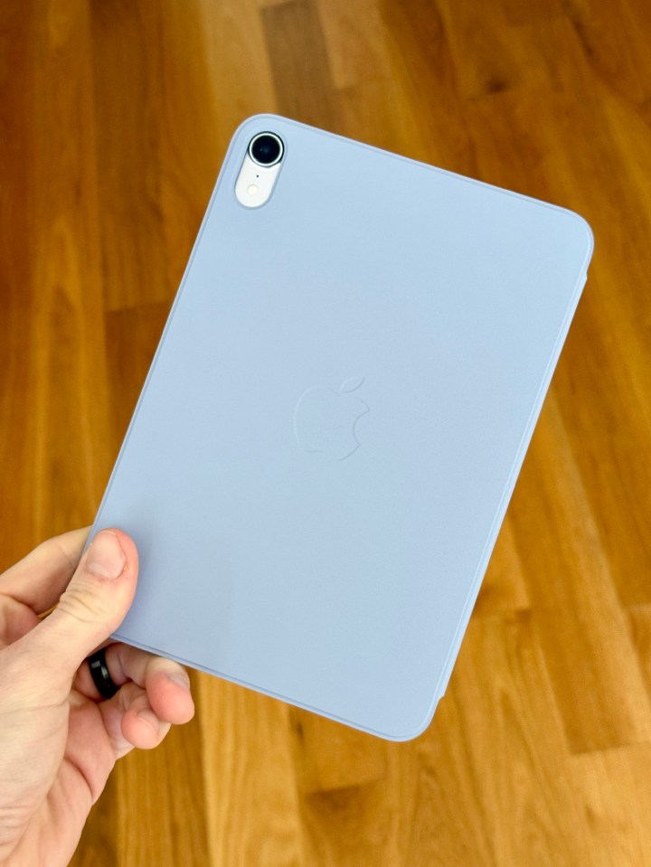 a person is holding a light blue apple ipad