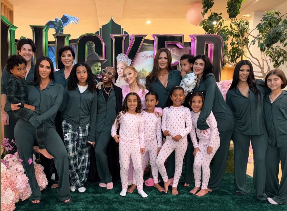 a group of people posing in front of a sign that says wicked