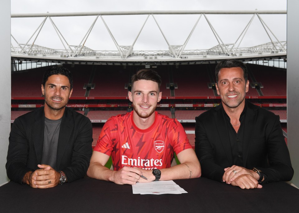 a man in a red emirates jersey sits between two men