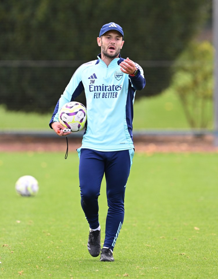 a man in an emirates fly better shirt holds a soccer ball