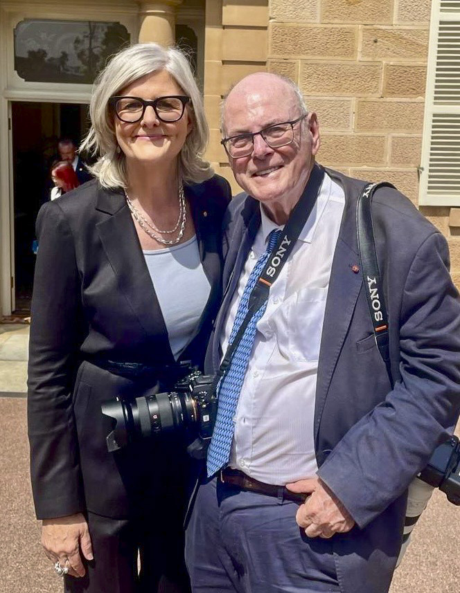 a man wearing a sony camera strap stands next to a woman