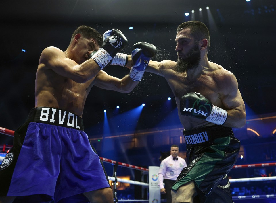 two boxers are fighting in a ring with one wearing rival boxing gloves