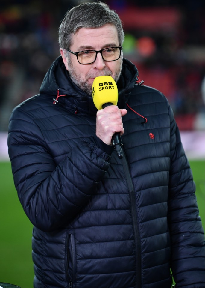 a man in a bbc sport jacket holds a yellow microphone