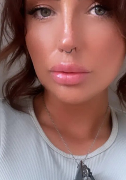 a close up of a woman 's face with a nose ring