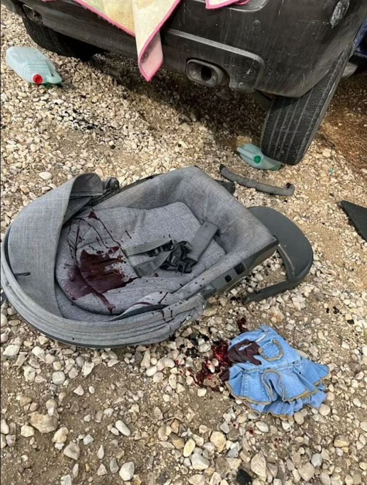 A baby’s seat and child’s dress is seen covered in blood in the aftermath of a Hamas attack