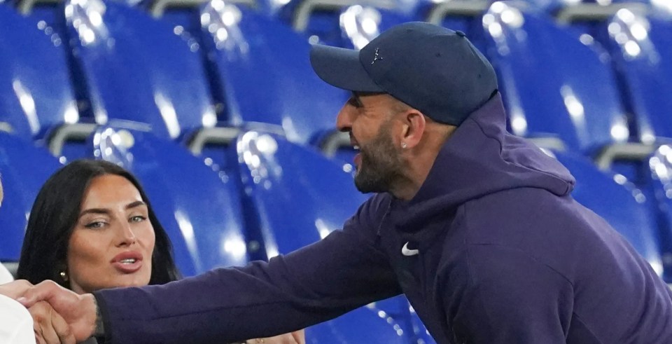 a man wearing a nike hat shakes hands with a woman