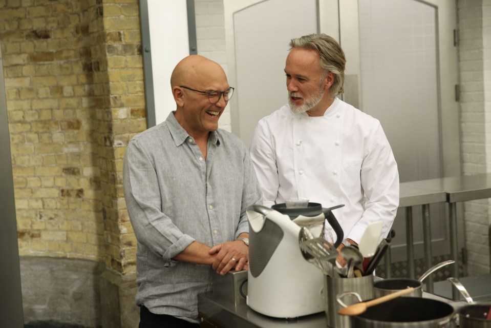 two men shaking hands in front of a kitchen counter