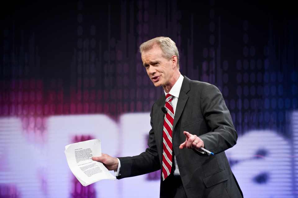 a man in a suit and tie is holding a piece of paper