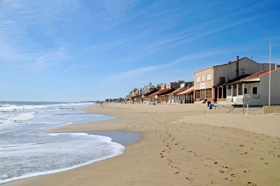 a row of houses on a beach with a sign that says ' alquiler ' on it