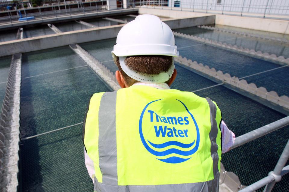 a man wearing a yellow vest that says thames water