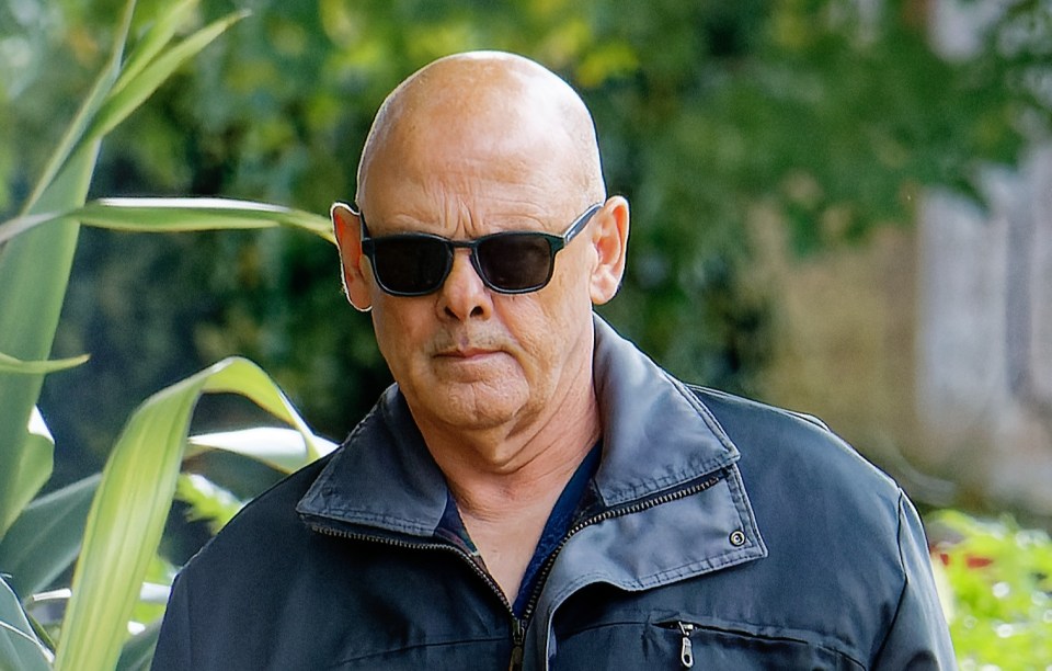 a bald man wearing sunglasses and a black jacket